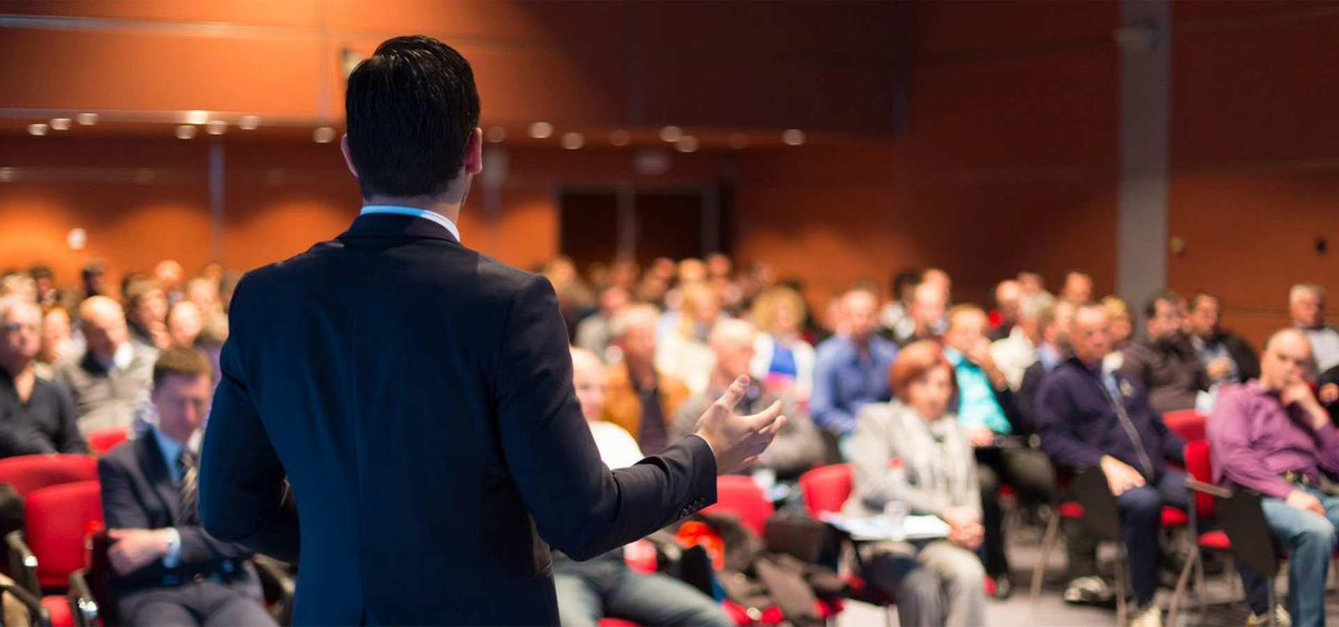 A man speaking with people in a conference hall